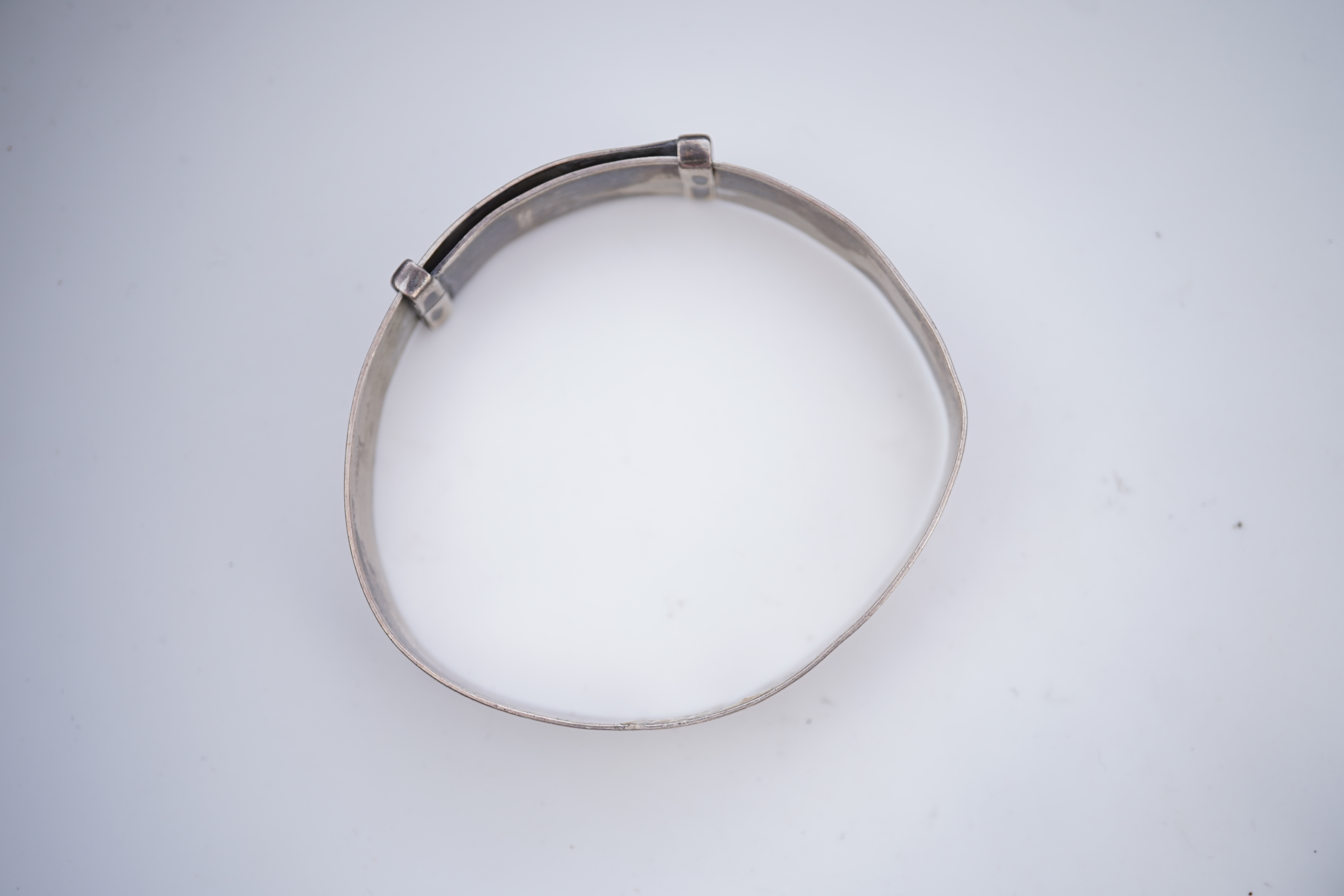 A collection of silver jewels, comprising: a bangle; a chain necklace suspending two winding toothpicks, one with toothpick deficient; a rope twist chain; a pair of cufflinks with the initials DBH; a pendant of abstract